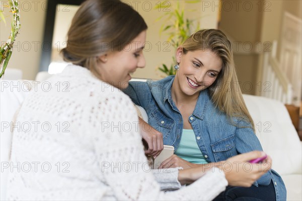 Caucasian women using cell phone on sofa