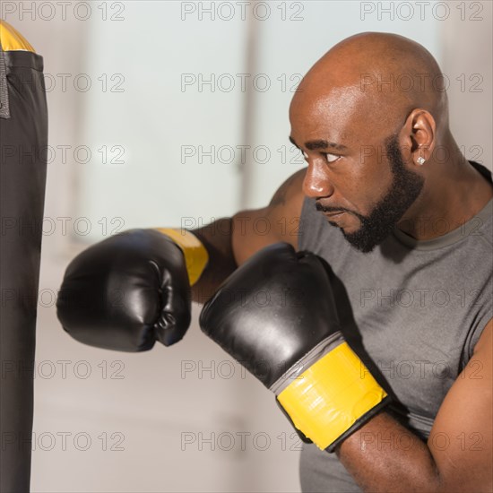 Black boxer training with punching bag