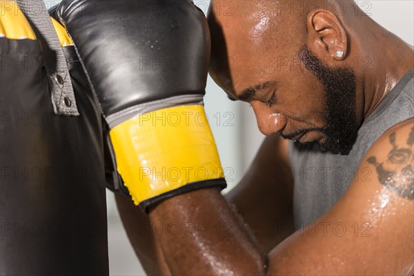 Black boxer training with punching bag