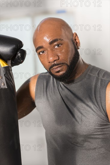 Black boxer training with punching bag