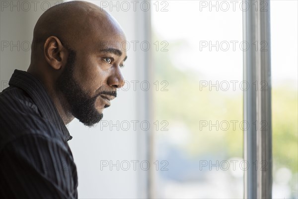 Black man looking out window