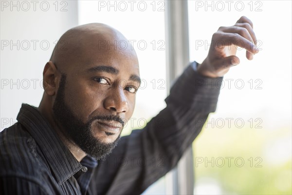 Black man standing at window