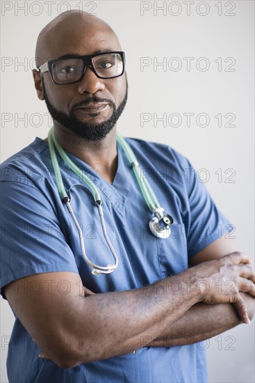 Black nurse standing with arms crossed