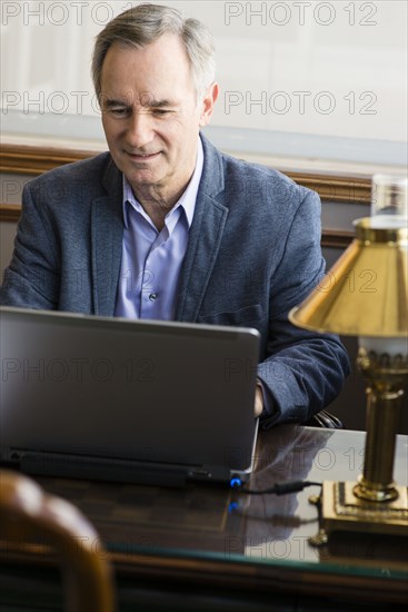 Caucasian businessman working on laptop at desk