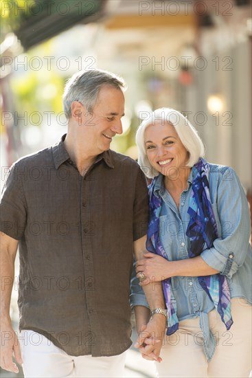 Older Caucasian couple holding hands outdoors