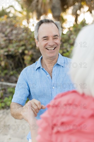 Close up of older Caucasian couple talking on beach