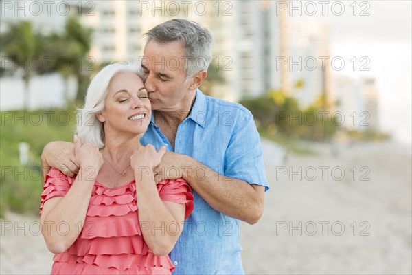 Older Caucasian couple walking on beach