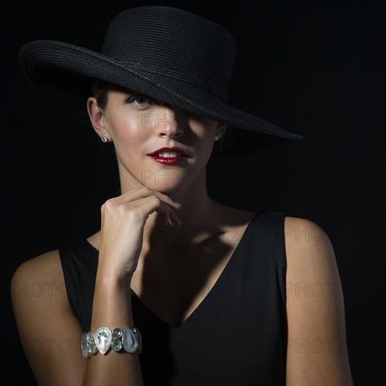 Stylish Caucasian woman wearing black hat and dress