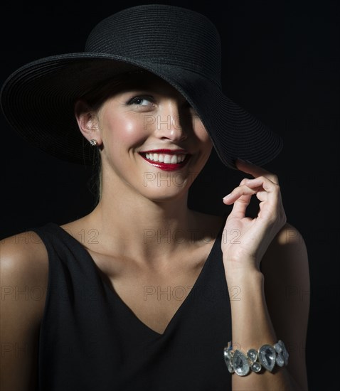 Stylish Caucasian woman wearing black hat and dress