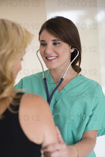 Doctor listening to heartbeat of patient in hospital