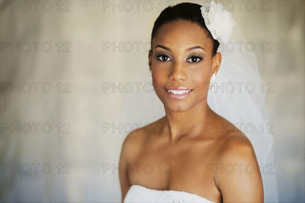 Mixed race bride wearing wedding gown and veil