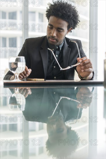 Hispanic businessman using cell phone at conference table