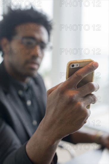 Hispanic businessman using cell phone in office