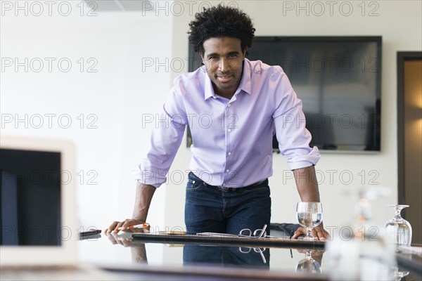 Hispanic businessman leaning over conference table