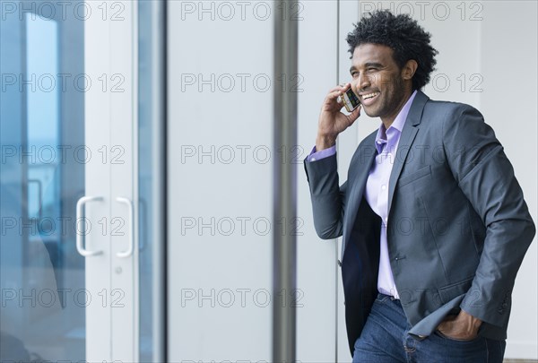 Hispanic businessman talking on cell phone in office