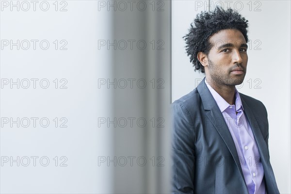 Serious Hispanic businessman at office window