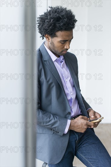 Hispanic businessman using cell phone in office