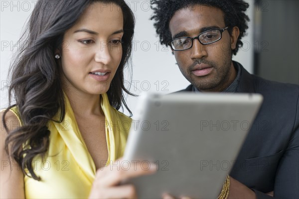 Hispanic business people using digital tablet