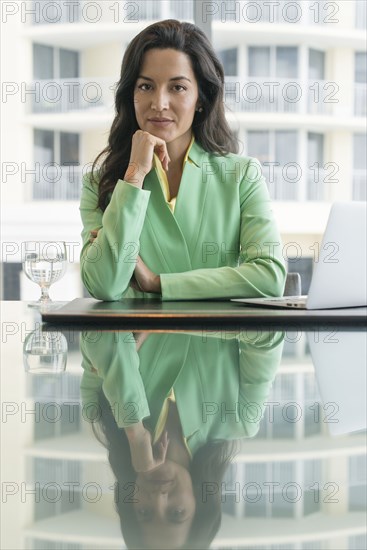 Hispanic businesswoman sitting at conference table