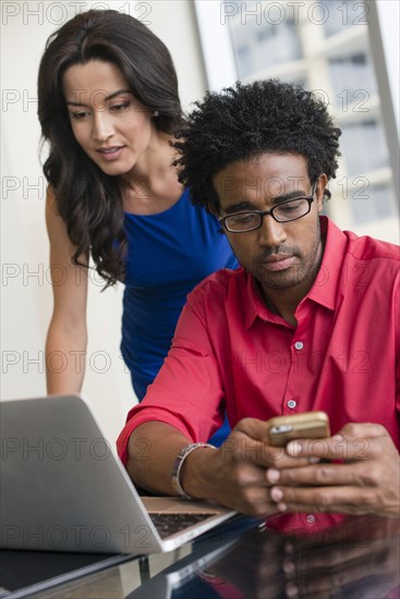 Hispanic business people working at office desk