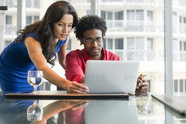 Hispanic business people working at office desk