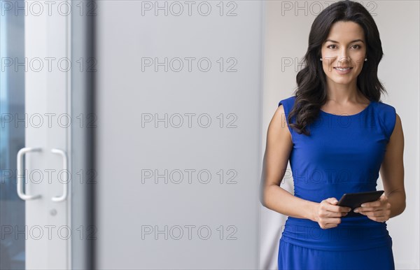 Hispanic businesswoman using digital tablet in office