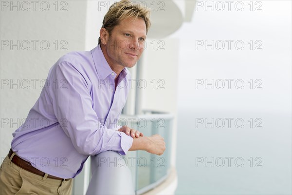 Caucasian businessman leaning on balcony