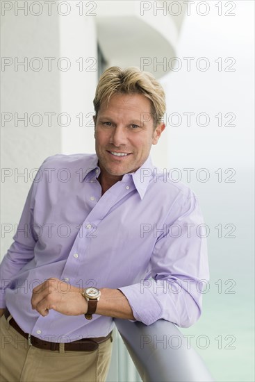 Caucasian businessman leaning on balcony