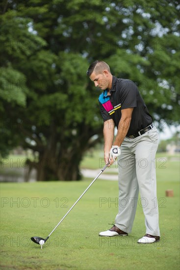 Caucasian man teeing off on golf course