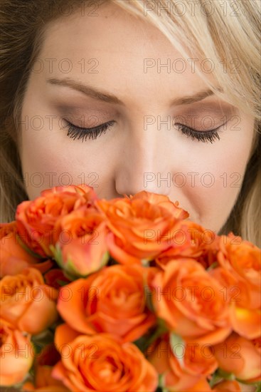Caucasian woman smelling bouquet of flowers