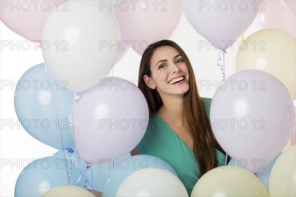 Hispanic woman standing with balloons