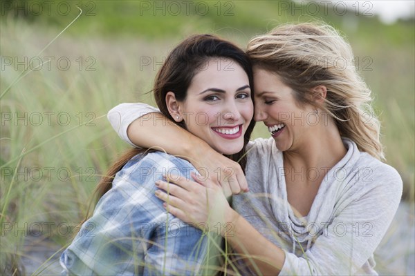 Smiling women hugging on beach