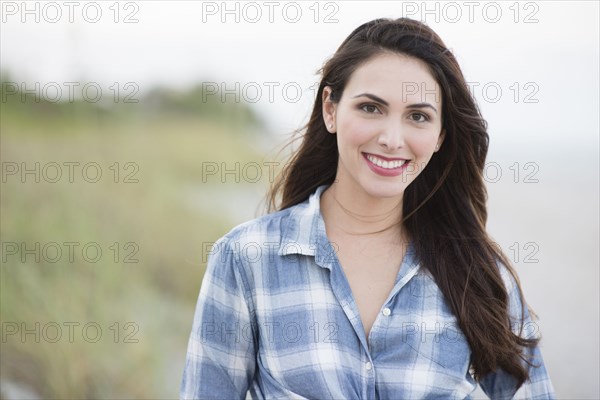 Hispanic woman smiling on beach