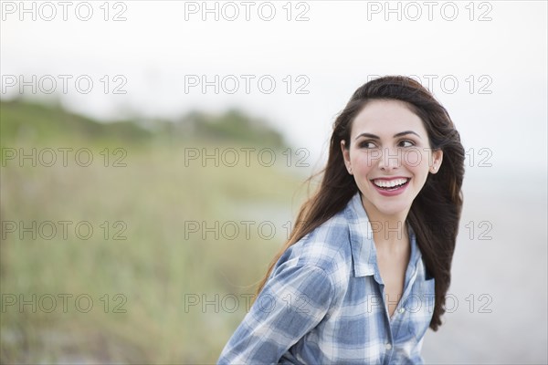 Hispanic woman smiling on beach