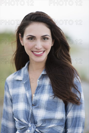 Hispanic woman smiling on beach