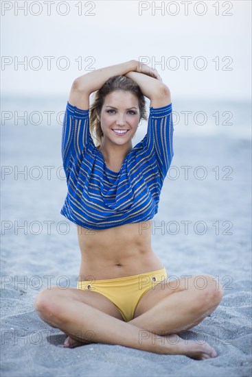 Caucasian woman sitting on beach