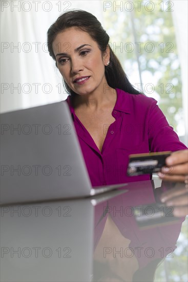 Hispanic woman shopping online with laptop