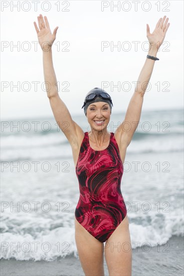 Caucasian swimmer standing on beach