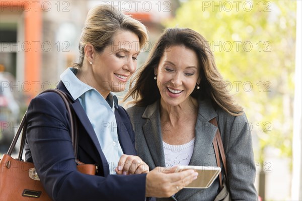 Caucasian businesswomen using digital tablet outdoors