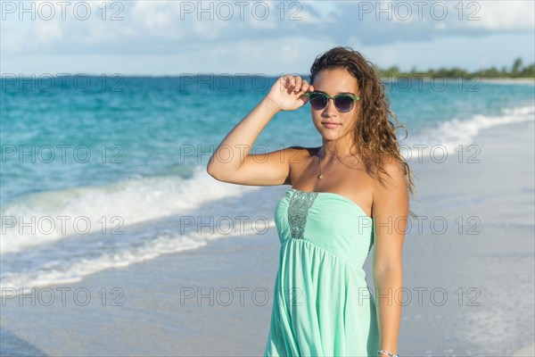 Hispanic teenage girl standing on beach