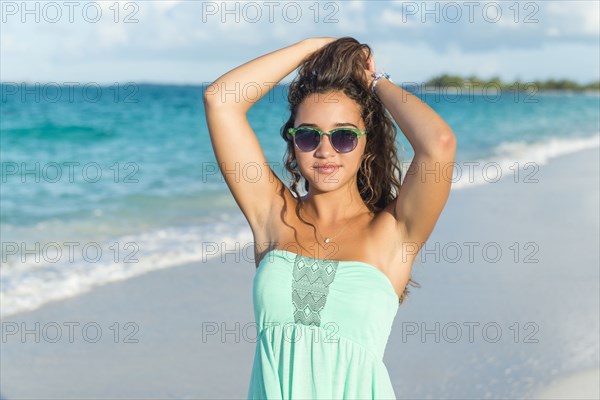 Hispanic teenage girl standing on beach