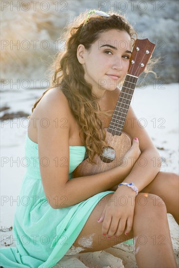 Hispanic teenage girl holding ukulele