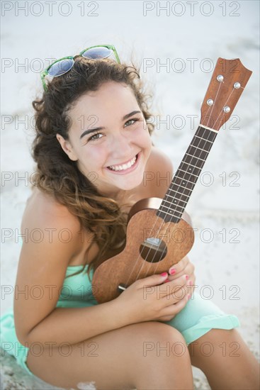 Hispanic teenage girl holding ukulele