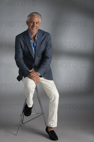 Caucasian businessman smiling on stool