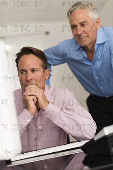 Caucasian businessmen working at computer