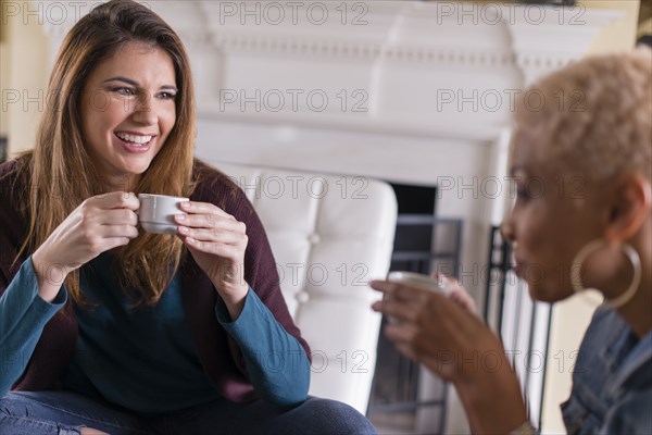 Women drinking coffee in living room