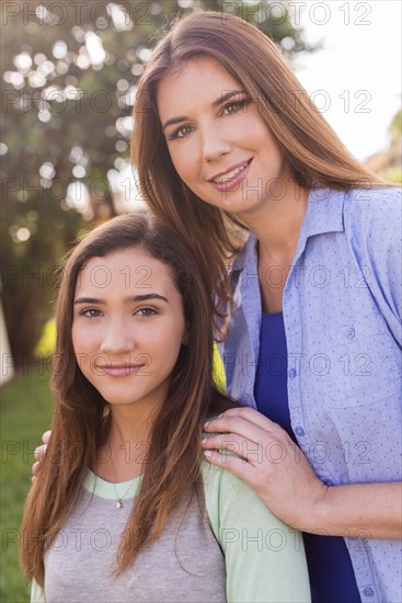 Mother and daughter smiling outdoors