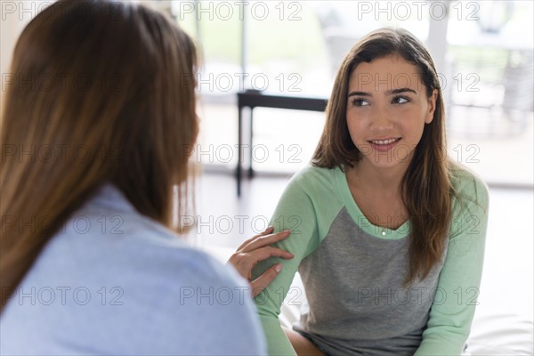 Mother and daughter talking indoors