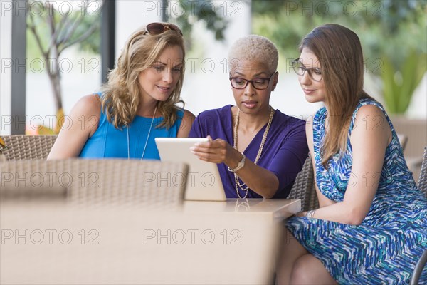 Businesswomen using digital tablet at table