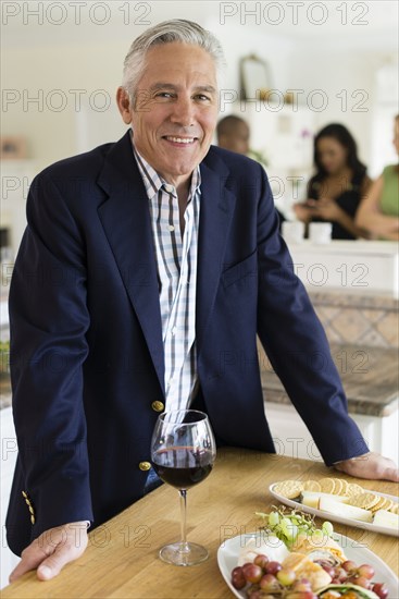 Caucasian man drinking wine at party